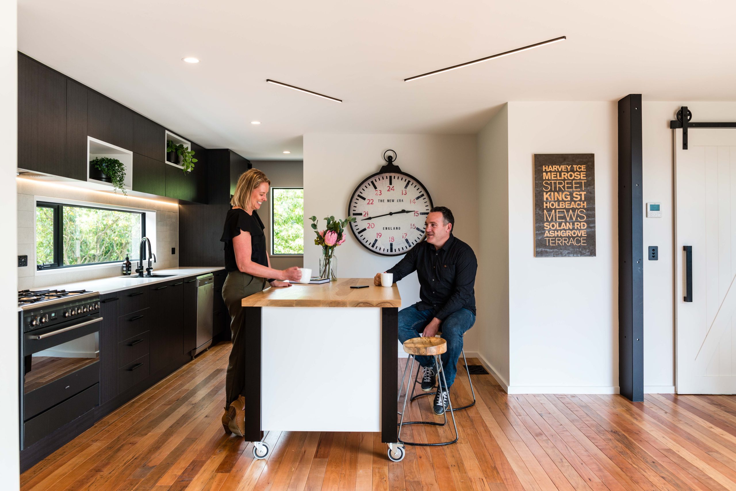 Couple having a conversation in their newly renovated industrial chic kitchen.